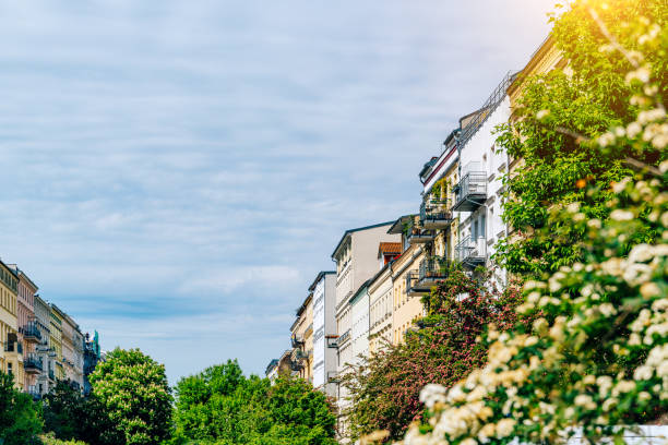 Urban residential view in Berlin featuring classic buildings, lush greenery, and clear skies, creating a picturesque atmosphere.