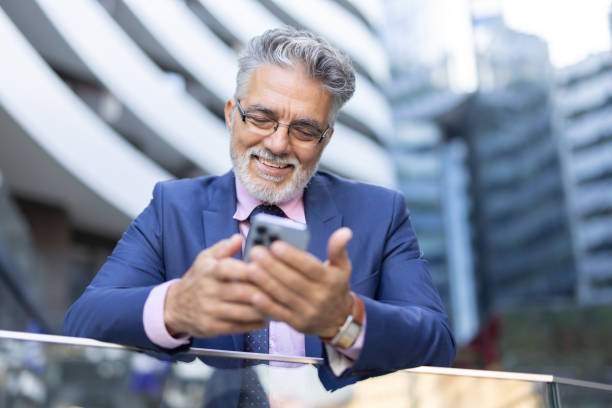 istock Successful businessman enjoying technology outside building 2204549084