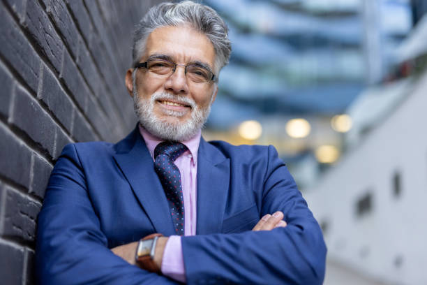 istock Confident businessman smiling while leaning against a wall 2204549138