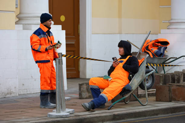 Moscow, Russia - March 10, 2025: Two municipal workers in uniform resting  during repair works