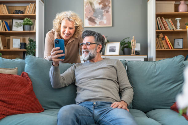 istock Mature couple looking together at mobile phone 2204552798