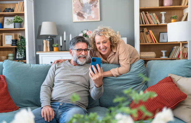 istock Mature couple looking together at mobile phone 2204552831