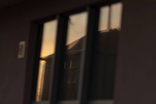 A beautiful sunset is vividly reflected in the glass window of a tall building, creating a stunning visual experience