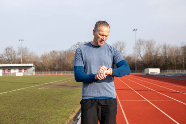 istock Mature male athlete setting a smart watch on a running track 2204554325