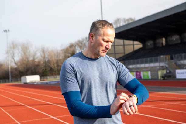 istock Mature male athlete setting a smart watch on a running track 2204554334