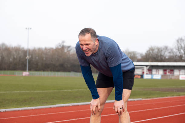 istock Tired mature male athlete with hands on his knees 2204554496