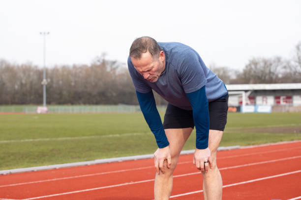 istock Tired mature male athlete with hands on his knees 2204554510
