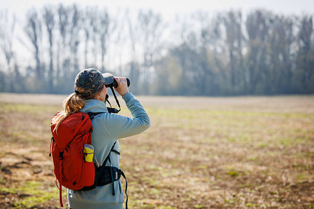 istock Woman explorer with binoculars watching birds arriving at early spring 2204555979