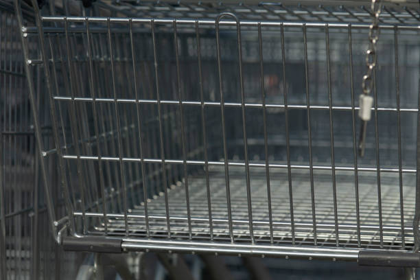 istock A shopping cart that is completely empty, featuring a chain hanging from it 2204557434