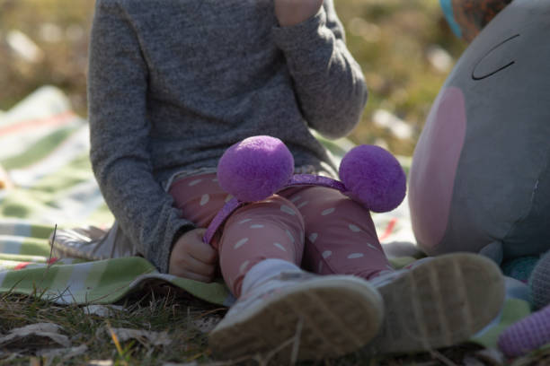 istock A girl sits on a blanket, happily holding a stuffed toy 2204562084