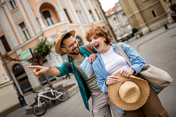 Young couple using a map to explore the new city on their vacation.