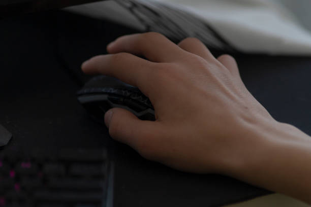 Details of woman's hands working using a mouse on a desktop
