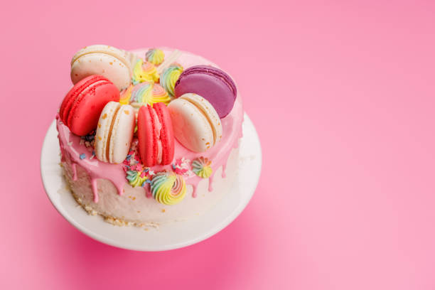 A beautifully decorated cake adorned with colorful macarons and vibrant decorations, creating a visually appealing and delicious dessert perfect for celebrations and special occasions
