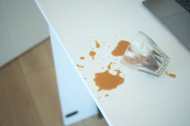 istock A drink was accidentally spilled on a desk with a laptop and glasses, creating a mess 2204568897