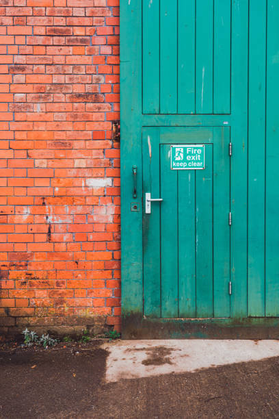 istock Green fire exit door and red brick wall in bristol, england 2204570580