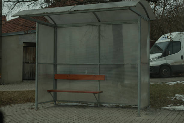 A bus stop shelter with a bench against a gray background captures the essence of urban transportation