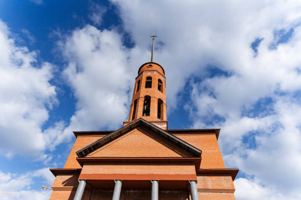 Top part of old church with cross on roof against clear blue sky background with copy space, silhouette, full frame horizontal composition