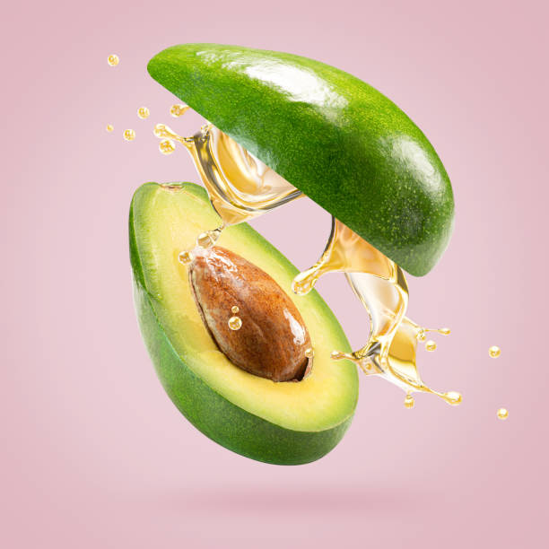 istock avocado with oil splash on a light pink background 2204573276