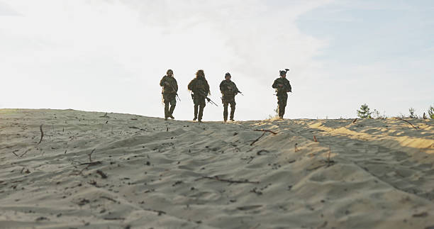 A group of soldiers completes their mission, coming down from an observation post with helmets secured and rifles ready, participating in the changing of the guard during training.