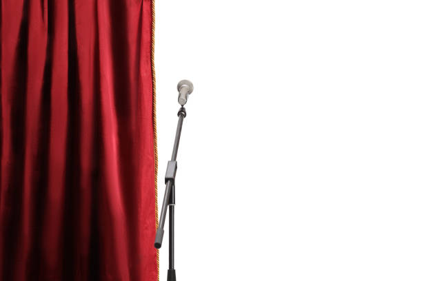 Microphone on a stand in front of a red stage curtain isolated on white background