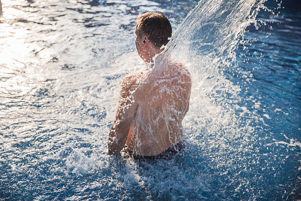 istock Man enjoying relaxing shower in a swimming pool 2204575137
