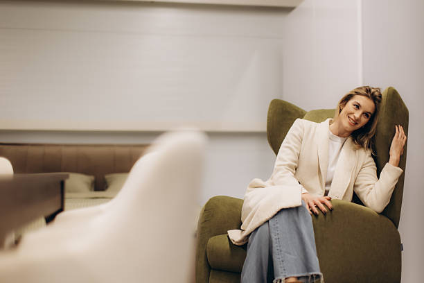 istock Smiling Woman Relaxing on an Olive Colored Sofa in a Cozy Room 2204577126