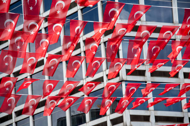 Turkish flags strung on a rope in front of a modern building - Kızılay square