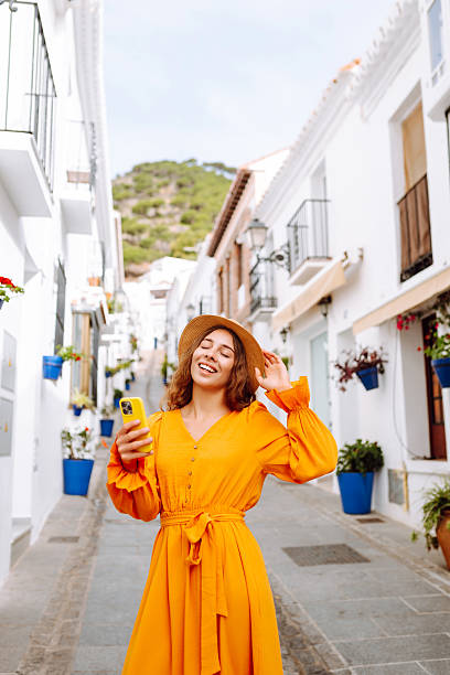 istock Cheerful woman taking selfie on phone while walking in old town. 2204577845