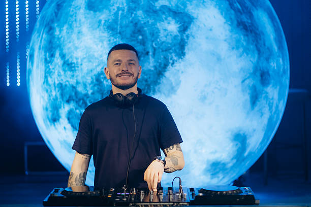 istock DJ Performing Against Vibrant Moonlit Backdrop at a Nighttime Event 2204577966