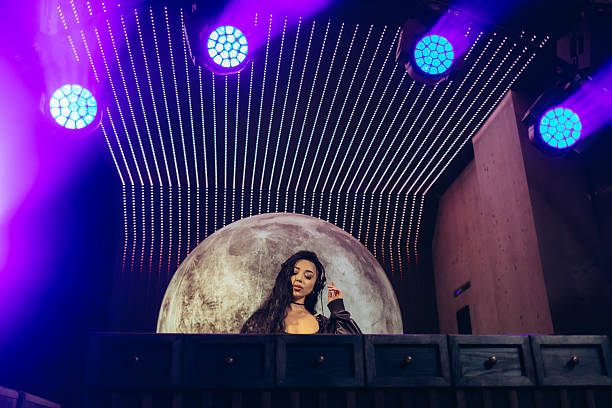istock DJ Performing at a Stylish Nightclub Under Dynamic Lights and Moon Background 2204578542