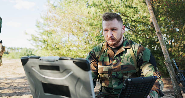 istock The serious and experienced army commander sits in the field, having a video conversation on a computer with the head of the army base, discussing action details and security precautions. 2204579285