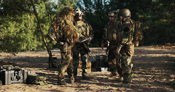 istock Military troops in camouflage uniforms and helmets secure the base area, carrying long rifles and monitoring crates of equipment during intense territorial defense drills. 2204579421