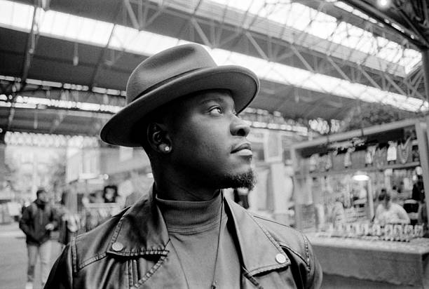 istock Stylish man wearing a hat looking up in a market 2204579466