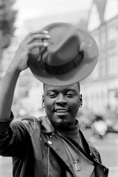 istock Stylish man lifting his hat in a grainy black and white portrait 2204579472