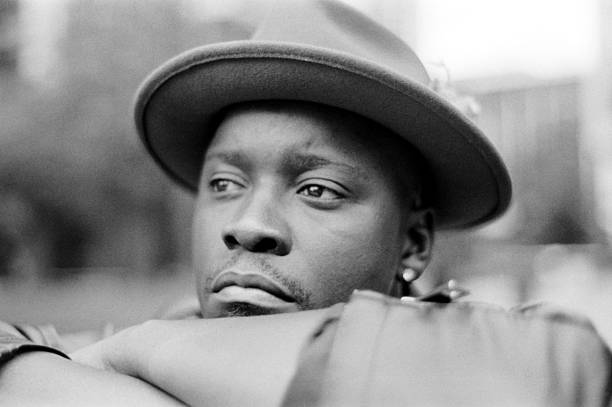 Pensive musician resting and looking away while wearing a hat