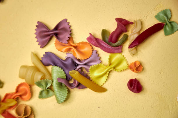 istock bright yellow background with colorful macaroni 2204581524
