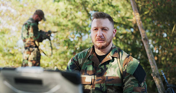 istock The serious army commander, positioned in the field, holds a video conversation with the head of the army base, briefing him on actions taken and classified security protocols. 2204582482