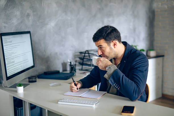 istock Businessman drinking a cup of coffee in his office 2204583297