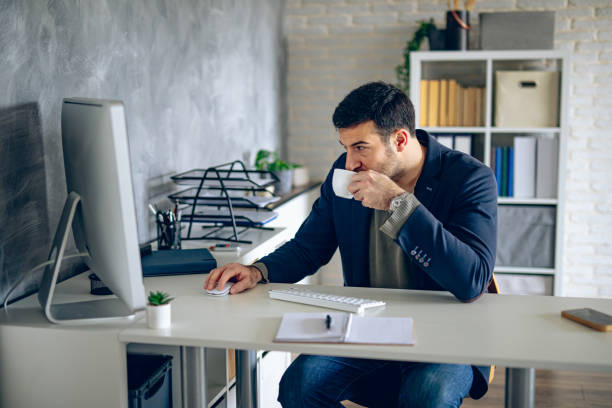 istock Businessman drinking a cup of coffee in his office 2204583313