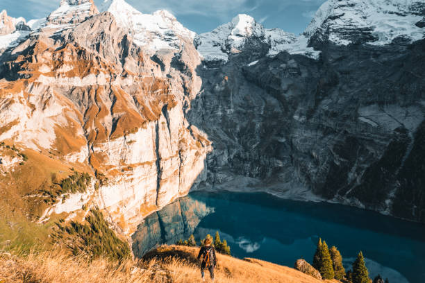 istock Young man hikes above lake and mountains 2204585341