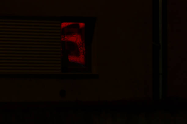 istock In a dark room, there is a red light shining out of a window 2204588295