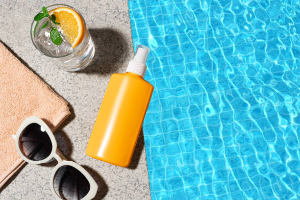 istock Sunscreen bottle and cocktail drink near pool water 2204589004