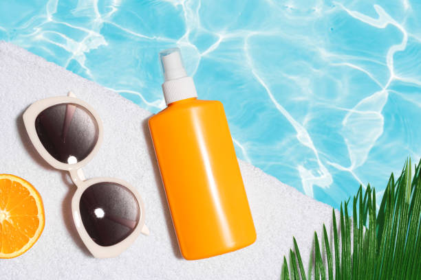 istock Sunscreen bottle and sunglasses near pool water 2204589045