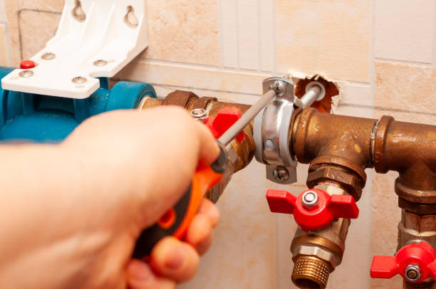 istock A plumber tightens a metal clamp on a copper pipe using a screwdriver during repairs. 2204590112