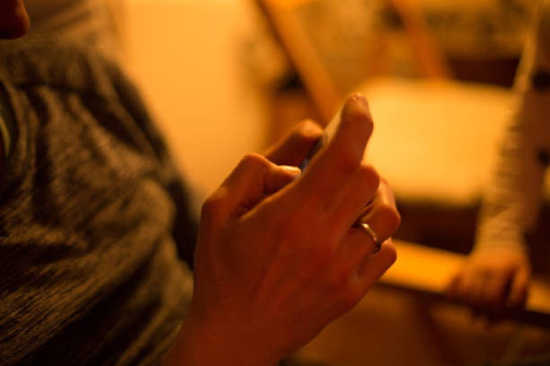 istock Hands Holding Smartphone in Dim Lighting Conditions During Nighttime 2204590308