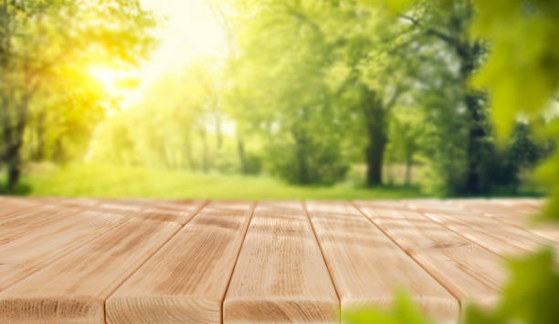 istock Empty wooden table top on green nature background. Copy space for products. 2204590517