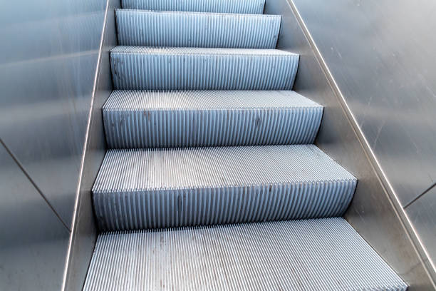 Metallic escalator steps with grooved texture, commonly found in metro stations, showing industrial design details.
