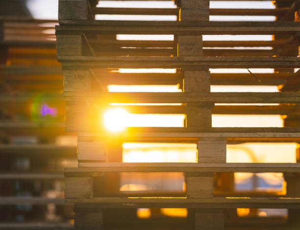 stacked wooden pallets with sunlight streaming through..