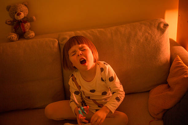 istock A Young Child is Crying on a Sofa with a Teddy Bear in the Background 2204594767
