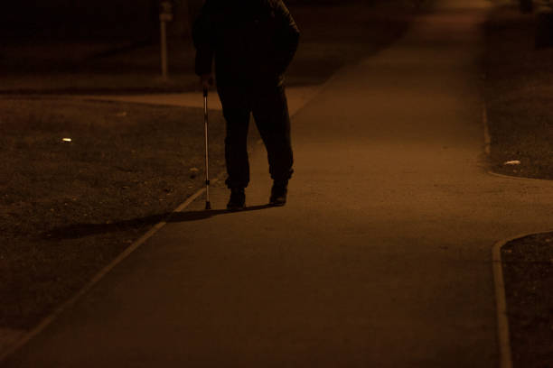 istock A person who uses a cane is walking along a sidewalk during the night 2204597927